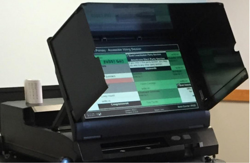 Black privacy partition atop black base surrounds LCD screen with green boxes.